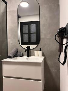a bathroom with a white sink and a mirror at Terrazas de la Catedral II in Castellón de la Plana