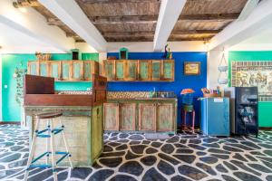 a kitchen with wooden cabinets and blue walls at Kai's Beachfront Villa in Gili Islands