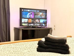 a living room with a tv and a pile of towels at Le Cocon Cathédrale in Metz