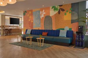a living room with a blue couch and two tables at DoubleTree by Hilton Rotterdam Centre in Rotterdam