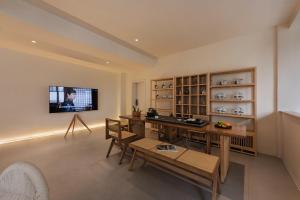 a living room with a table and a tv on the wall at Mountain Resort Hotel in Dali