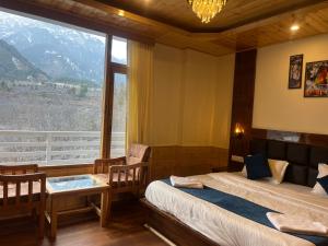 a bedroom with two beds and a large window at Liora Stays in Palchān