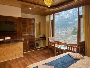a bedroom with a bed and a large window at Liora Stays in Palchān +12 photos