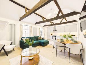 a living room with a green couch and a table at NEW Artisan Apartment by Signature Stays - Modern - Spacious - Parking in Cheltenham