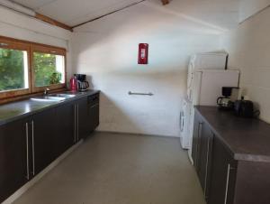 a kitchen with black cabinets and a white refrigerator at Les Renaudières Chalais in Chalais +8 photos
