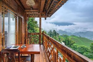 a balcony with a desk and a view of a mountain at 素隐乡宿Hometown Destination红瑶吊脚楼 观景民宿 in Heping