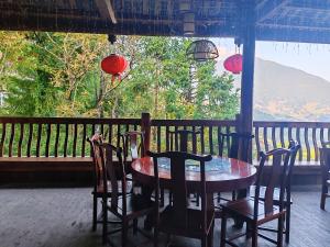 a table and chairs sitting on a porch with a view at 素隐乡宿Hometown Destination红瑶吊脚楼 观景民宿 in Heping