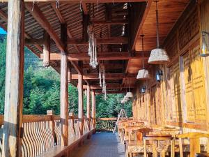 a large wooden building with tables and chairs at 素隐乡宿Hometown Destination红瑶吊脚楼 观景民宿 in Heping