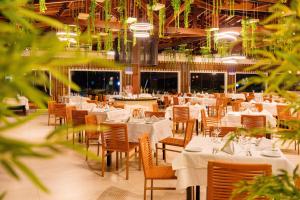 a dining room with white tables and chairs at Grand Oca Maragogi All Inclusive Resort in Maragogi