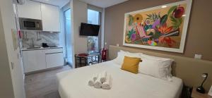 a bedroom with a white bed with shoes on it at Cais 75 Studios & Suites in Aveiro
