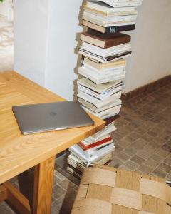 a stack of books sitting next to a table with a laptop at Casa Teva Rooms Sevilla in Seville