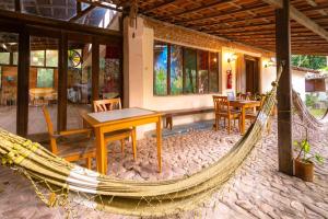 a hammock in a house with a table and chairs at Hospedaria Quintal dos Sonhos in Vale do Capao