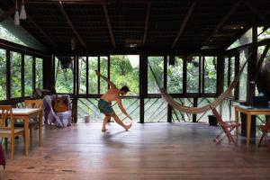a young boy playing in a room with hammocks at Hospedaria Quintal dos Sonhos in Vale do Capao