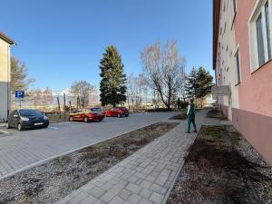 a man standing on a sidewalk next to a building at Apartmán PP Tatry in Jezersko