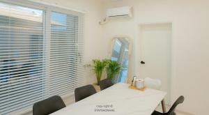 a dining room with a white table and chairs and a window at Stay Gaonhae in Gyeongju