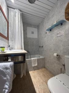 a bathroom with a tub and a sink and a toilet at Hotel Apartamentos Solimar in Calafell