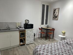 a room with a bed and a kitchen and a table at Studio proche vieux port in Marseille