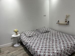 a white bedroom with a bed and a table at Studio proche vieux port in Marseille