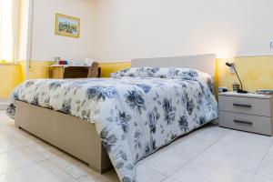 a bedroom with a bed with a blue and white comforter at Guest House Margherita in Caserta
