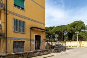 a yellow building with a fence next to a street at Guest House Margherita in Caserta
