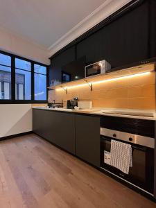 a kitchen with black walls and yellow tiles at Terrazas de la Catedral III in Castellón de la Plana