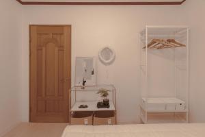 a white room with a door and a shelf and a room with a shelf at 퍼즈스테이 Pause Stay in Chuncheon