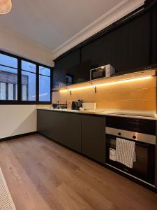 a kitchen with black walls and yellow tiles at Terrazas de la Catedral III in Castellón de la Plana +29 photos