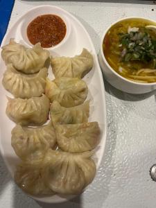 a plate of food with dumplings and a bowl of soup at Liora Stays in Palchān