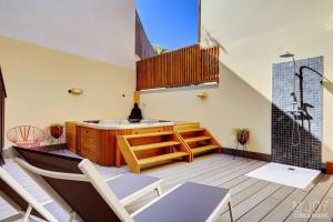 a balcony with a tub and a table and chairs at TIGOUYA - House of 135m - 2 bedrooms Jacuzzi in Stella Matutina