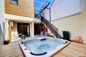 a hot tub on a deck in front of a house at TIGOUYA - House of 135m - 2 bedrooms Jacuzzi in Stella Matutina