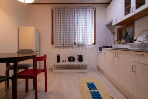 a small kitchen with a table and a refrigerator at 퍼즈스테이 Pause Stay in Chuncheon