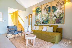 a living room with a green couch and a blue chair at VILLA ESCALE TROPICALE - classée 5 in Petite Île