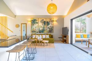 a living room with a green couch and chairs at VILLA ESCALE TROPICALE - classée 5 in Petite Île