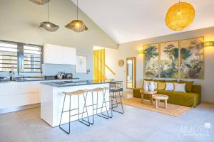 a kitchen and living room with a green couch at VILLA ESCALE TROPICALE - classée 5 in Petite Île +21 photos