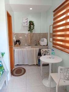 a kitchen with a table and a sink and a table and chairs at JAG Homes in Puerto Princesa City