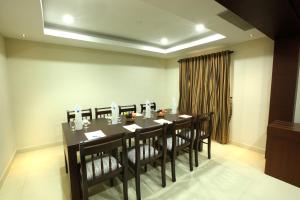 a dining room with a long table and chairs at Hotel Indraprastha Thiruvananthapuram in Trivandrum +10 photos