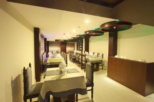 a dining room with white tables and chairs at Hotel Indraprastha Thiruvananthapuram in Trivandrum