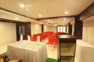 a conference room with red chairs and tables and candles at Hotel Indraprastha Thiruvananthapuram in Trivandrum