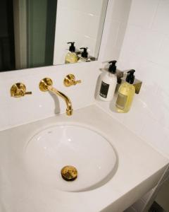 a bathroom sink with a gold faucet and a mirror at Casa Teva Rooms Sevilla in Seville +36 photos