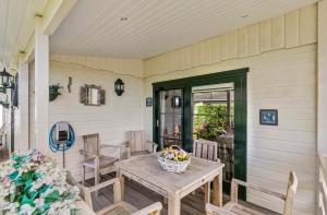 a porch with a wooden table and chairs at De Bosparel in Doldersum