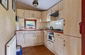 a kitchen with wooden cabinets and a sink and a stove at De Bosparel in Doldersum
