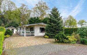 a white house with a tree in front of it at De Bosparel in Doldersum