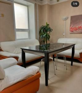 a living room with a glass table and a couch at Delight Сая in Astana