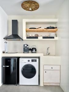 a kitchen with a stove and a washing machine at Cozy Hideaway Room with Private Jacuzzi in Krotiri