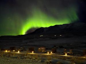an image of the aurora in the sky over a field at Aurora Igloo North in Hvammstangi