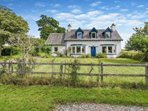 a white house with a blue door and a fence at 5 Bed in Dunkeld oc-90585 in Dunkeld