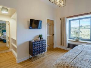 a bedroom with a bed and a tv on a wall at 3 Bed in Colne oc-89582 in Colne
