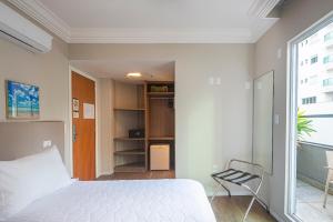 a bedroom with a bed and a chair in it at Hotel Melo in Balneário Camboriú