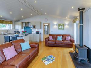 a living room with two leather couches and a stove at 3 Bed in St. Andrews oc-88545 in Balmullo