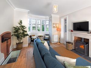 a living room with a blue couch and a fireplace at 3 Bed in Lockerbie oc-95861 in Brydekirk